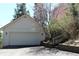 Detached garage with a red-trimmed roof and traditional door, set amongst mature trees and vegetation at 28650 Cavan Ln, Evergreen, CO 80439