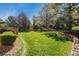 Lush backyard with mature landscaping provides a private outdoor retreat with a grassy lawn at 9188 Buck Hill Dr, Highlands Ranch, CO 80126