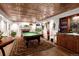 Finished basement features an ornate ceiling, wet bar, pool table and a living space with a fireplace at 9188 Buck Hill Dr, Highlands Ranch, CO 80126