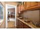 Butler's pantry with decorative cabinets, granite countertops, and access to the dining room at 9188 Buck Hill Dr, Highlands Ranch, CO 80126