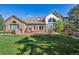 Back exterior view of the home showcases the patio, grill, and beautifully landscaped yard at 9188 Buck Hill Dr, Highlands Ranch, CO 80126