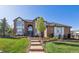 A well-manicured front yard featuring a brick home, steps leading to the front door, and mature landscaping at 9188 Buck Hill Dr, Highlands Ranch, CO 80126