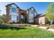 Beautifully landscaped front yard with a brick home and a charming water feature at 9188 Buck Hill Dr, Highlands Ranch, CO 80126