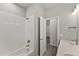 White tiled shower next to bathroom vanity and doorway at 16838 Greyhawk Dr, Monument, CO 80132