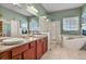 Luxurious bathroom featuring double sinks, marble countertops, a glass shower, and a freestanding tub at 42340 Kingsmill Cir, Elizabeth, CO 80107