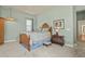 Cozy bedroom with wooden bed frame, side table, and light, featuring light green walls for a relaxing atmosphere at 42340 Kingsmill Cir, Elizabeth, CO 80107