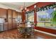 Charming dining area with natural light, wood floors, and decorative floral window valances at 42340 Kingsmill Cir, Elizabeth, CO 80107