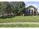 Lush lawn with mature trees, stone accents, and colorful shutters at 42340 Kingsmill Cir, Elizabeth, CO 80107