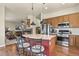 Open kitchen featuring stainless steel appliances, wood cabinets, and seating at the island at 42340 Kingsmill Cir, Elizabeth, CO 80107