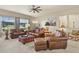 Spacious living room featuring plush leather seating, a ceiling fan, and ample natural light at 42340 Kingsmill Cir, Elizabeth, CO 80107