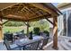 Relaxing outdoor dining area with shaded gazebo, dining table, and views of landscaped backyard at 42340 Kingsmill Cir, Elizabeth, CO 80107