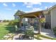 Covered outdoor seating area with a fire pit, grill and lawn with stone details, perfect for entertaining at 42340 Kingsmill Cir, Elizabeth, CO 80107