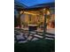 Outdoor seating area features a stone patio, a fire pit, string lights, and comfortable chairs under a pavilion at 42340 Kingsmill Cir, Elizabeth, CO 80107