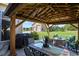 A covered outdoor seating area offers a grill, dining and lounge furniture, and a view of the detached garage at 42340 Kingsmill Cir, Elizabeth, CO 80107