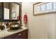 Stylish powder room featuring a vessel sink, granite countertop, and decorative mirror at 42340 Kingsmill Cir, Elizabeth, CO 80107