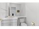 Simple and clean powder room with white fixtures, a large mirror, and tile countertop at 2032 W Nantucket Ct, Littleton, CO 80120