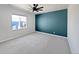A bright bedroom features neutral carpet, white walls, and accent wall for natural light at 10689 Uravan St, Commerce City, CO 80022