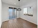 Bright dining area features sliding glass doors, modern pendant lighting, and wood-look floors at 10689 Uravan St, Commerce City, CO 80022