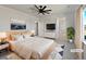 Staged main bedroom featuring a large bed, a ceiling fan and plant for decor at 10689 Uravan St, Commerce City, CO 80022