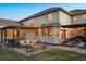 Backyard featuring a stone patio with fire pit, outdoor seating, hot tub and string lights at 223 Castlemaine Ct, Castle Rock, CO 80104