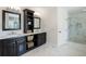 Bathroom features a double vanity, marble floors, and a glass enclosed shower at 223 Castlemaine Ct, Castle Rock, CO 80104