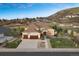 Aerial view of a tan two-story home with a three-car garage situated on a picturesque lot at 223 Castlemaine Ct, Castle Rock, CO 80104