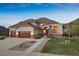 Charming home featuring an attached three car garage, manicured lawn, and stone accents at 223 Castlemaine Ct, Castle Rock, CO 80104