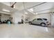 Spacious garage with epoxy floors, a parked vehicle and plenty of room for storage and hobbies at 223 Castlemaine Ct, Castle Rock, CO 80104