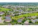 An aerial view showcases a neighborhood nestled beside a lush golf course with green fairways and well-manicured lawns at 8267 S Sicily Ct, Aurora, CO 80016