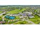 This aerial view shows a golf course with tennis courts, a parking lot, a clubhouse, and well-maintained landscaping at 8267 S Sicily Ct, Aurora, CO 80016