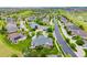 This aerial view shows homes along a street with green lawns and mature trees in a suburban community at 8267 S Sicily Ct, Aurora, CO 80016