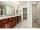 Bright Primary bathroom with a dual sink vanity, natural light, and open door to a closet at 8267 S Sicily Ct, Aurora, CO 80016
