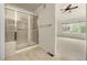 Bright bathroom with glass shower, tiled walls, neutral carpet, and a ceiling fan at 8267 S Sicily Ct, Aurora, CO 80016
