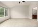 Spacious bedroom with plush carpeting, natural light, ceiling fan, and adjoined ensuite bathroom at 8267 S Sicily Ct, Aurora, CO 80016