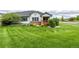 Expansive green front lawn, complemented by garden beds, well-kept shrubs and home with grey trim accents at 8267 S Sicily Ct, Aurora, CO 80016