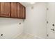 Functional laundry room with overhead cabinets, tiled floor, and utility connections at 8267 S Sicily Ct, Aurora, CO 80016