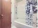 Bathroom featuring a bathtub, a curtain with seashell prints, and a wood door at 18891 E Carmel Dr, Aurora, CO 80011