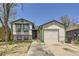 Charming home featuring a two-car garage, white siding, green trim, and a well-lit entryway with concrete walkway at 18891 E Carmel Dr, Aurora, CO 80011