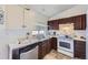 Kitchen featuring a stainless steel dishwasher, and white appliances with dark brown cabinets at 18891 E Carmel Dr, Aurora, CO 80011