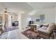 Bright living room area with rug and white walls next to a kitchen with stainless steel appliances at 18891 E Carmel Dr, Aurora, CO 80011