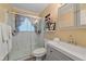 Modern bathroom featuring a marble-walled shower, gray vanity, and an organized shelf with decor at 4724 Hopi Rd, Indian Hills, CO 80454