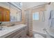 Bright bathroom featuring a tub with shower, patterned curtain, and modern gray vanity with ample storage at 4724 Hopi Rd, Indian Hills, CO 80454