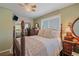 Comfortable bedroom featuring a decorative wood bed frame, neutral bedding, a ceiling fan and views from the window at 4724 Hopi Rd, Indian Hills, CO 80454