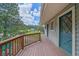 Deck with wooden railing offering views of the yard, trees and distant neighborhood at 4724 Hopi Rd, Indian Hills, CO 80454