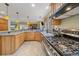 Spacious kitchen featuring stainless steel stove, light wood cabinets and updated countertops at 4724 Hopi Rd, Indian Hills, CO 80454