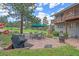 Outdoor patio features a dining set under a green umbrella, a fire pit and gas grill at 4724 Hopi Rd, Indian Hills, CO 80454