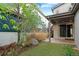 Turfed backyard with plants and rock, featuring a concrete patio and a covered area at 3384 Cranston Cir, Highlands Ranch, CO 80126