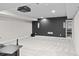 Finished basement with projector, neutral carpet, and black accent wall perfect for entertaining at 3384 Cranston Cir, Highlands Ranch, CO 80126