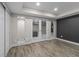Finished basement offers a gray accent wall, wood flooring, and glass french doors at 3384 Cranston Cir, Highlands Ranch, CO 80126