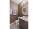 Chic powder room with stylish fixtures, unique mirror, and dark neutral color palette at 3384 Cranston Cir, Highlands Ranch, CO 80126